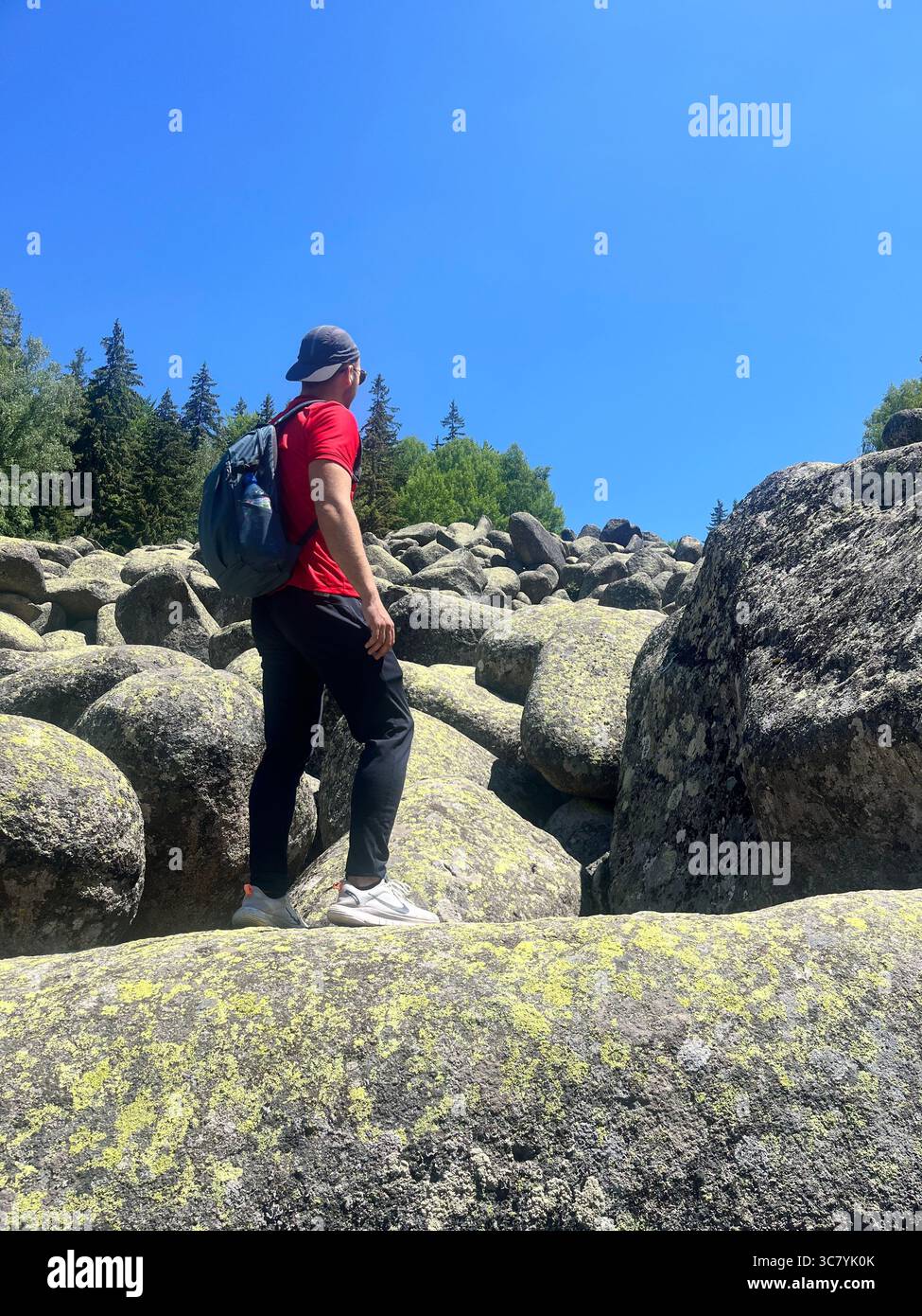 Männlicher Wanderer, der auf einem großen Felsbrocken am Steinfluss der Goldenen Brücken im Vitosha-Gebirge, Sofia Bulgarien, Südosteuropa, Balkan steht Stockfoto