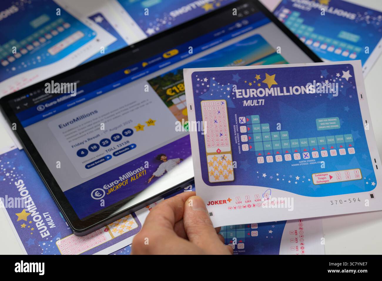 Brüssel, Belgien August 2025. Ein Lottospieler kreuzt ein Kästchen auf einem EuroMillions-Spielschein an, um Zahlen auf einer Wettkarte für den EuroMillions-Jackpot in dieser Fotoillustration am 2. August 2025 in Brüssel, Belgien, auszuwählen. (Foto: Jonathan Raa/NurPhoto) Credit: NurPhoto SRL/Alamy Live News Stockfoto