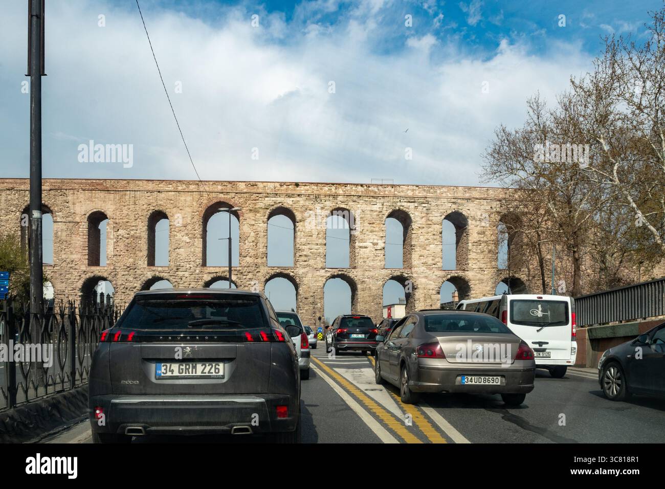 Autos fahren auf einer Straße in Istanbul, Türkei, mit dem Valens Aquädukt im Hintergrund. Stockfoto