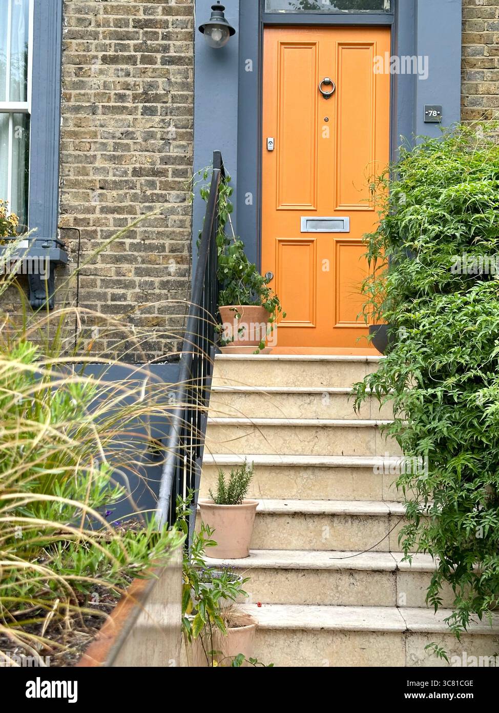 Eine gelbe Tür in einem Backsteinhaus in Peckham, London Stockfoto