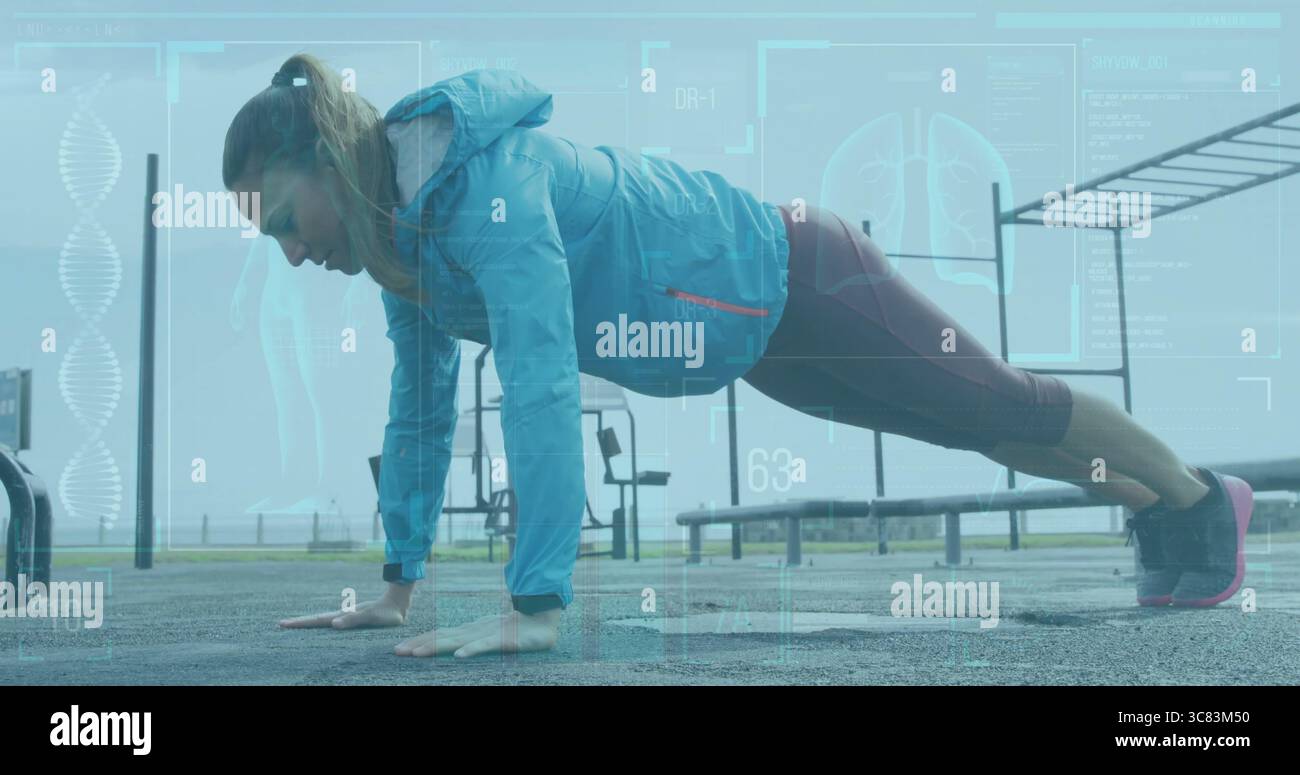 MittelErwachsene Frau in Sportbekleidung, die Liegestütze im Fitnessstudio im Freien, in Pull-up-Bars und im Fitness-Tracker durchführt Stockfoto