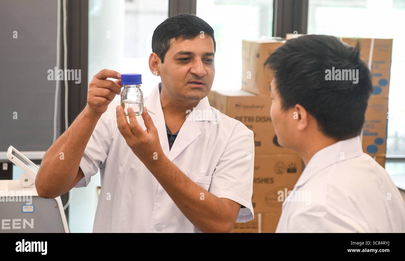 (250803) -- SANYA, 3. August 2025 (Xinhua) -- Waseem Raza spricht mit seinem Kollegen in einem tropischen Züchtungslabor der Chinesischen Akademie für tropische Agrarwissenschaften in Sanya, südchinesischer Provinz Hainan, 29. Juli 2025. Waseem Raza, ein 45-jähriger Pakistaner, arbeitet als Associate Researcher an der Chinesischen Akademie für tropische Agrarwissenschaften (CATAS). Er promovierte an der Landwirtschaftsuniversität Nanjing und trat der Universität bis 2024 als Fakultätsmitglied bei. In diesem Jahr wird er vom CATAS Sanya Research Institute über ein hochrangiges Talent-Programm rekrutiert und beginnt mit einem neuen Stockfoto