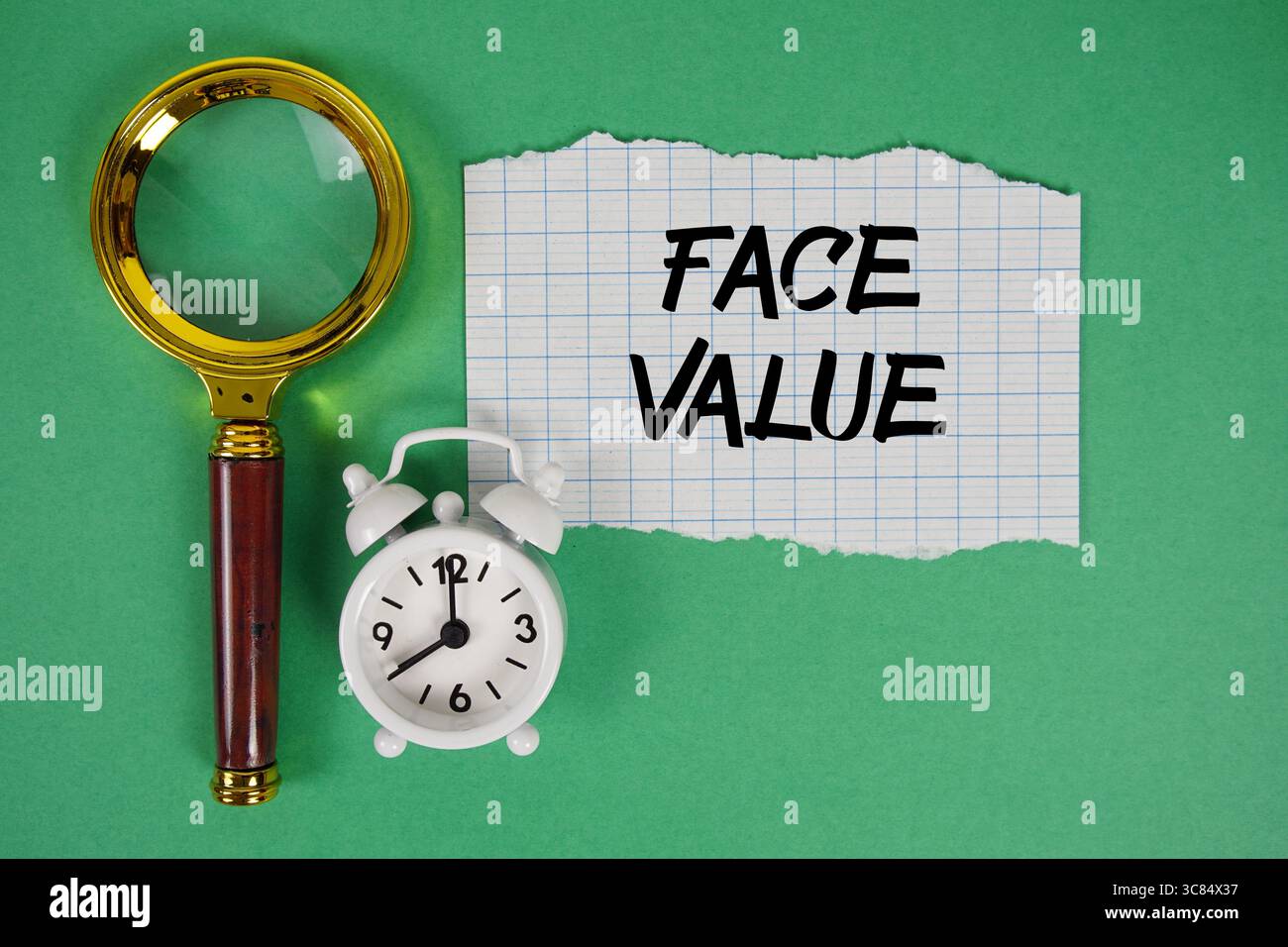 Auf Papier geschriebener Text mit Vergrößerungsglas und Wecker Stockfoto