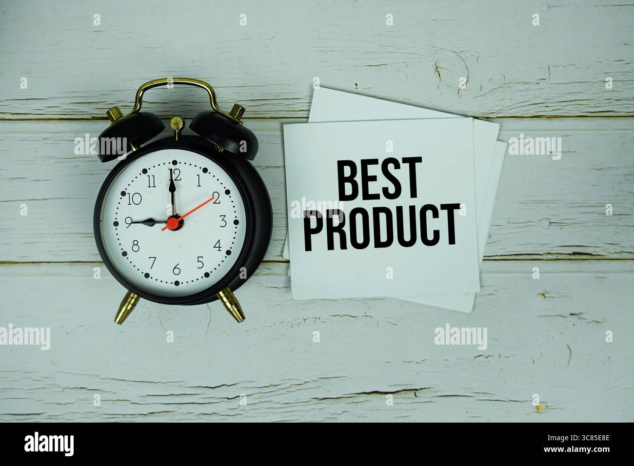 Textnachricht des besten Produkts auf Papier mit Wecker auf hölzernem Hintergrund Stockfoto