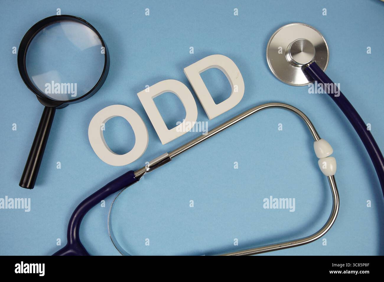 ODDER oppositioneller Defiant Disorder Text mit Stethoskop und Lupe auf blauem Hintergrund Stockfoto