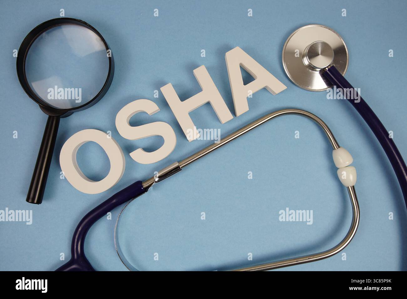 OSHA-Abkürzung für Occupational Safety and Health Administration Alphabet Buchstaben mit Lupe und Stethoskop auf blauem Hintergrund Stockfoto