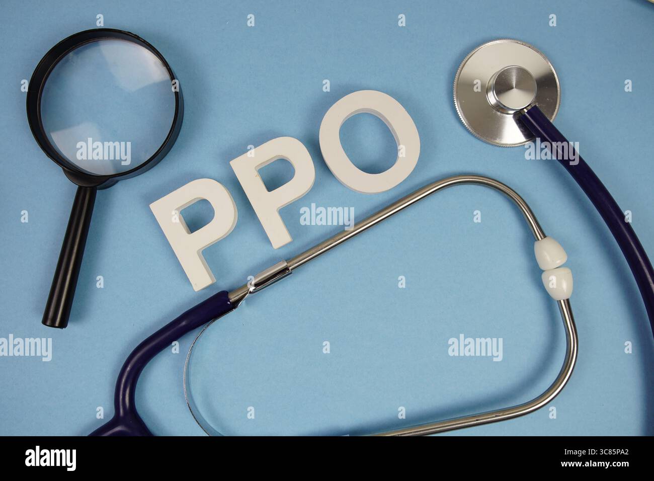 PPO-Abkürzung für Buchstaben der Preferred Provider Organization mit Lupe und Stethoskop auf blauem Hintergrund Stockfoto