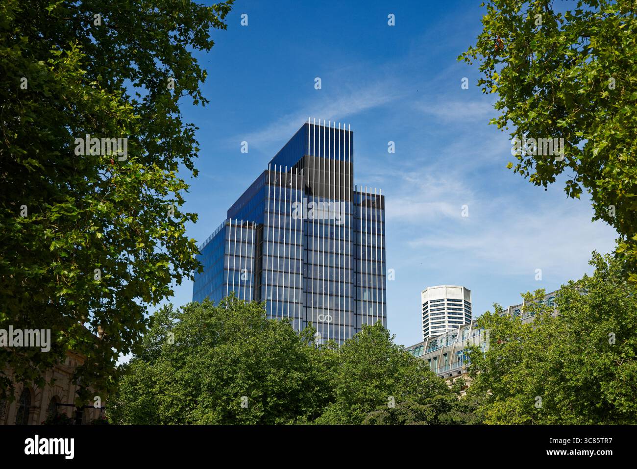 Die elegante Linie der 103 Colmore Row erhebt sich über den Bäumen mit der Spitze des Octagon Wolkenkratzers in einem blauen Himmel über dem Stadtzentrum von Birmingham, England. Stockfoto