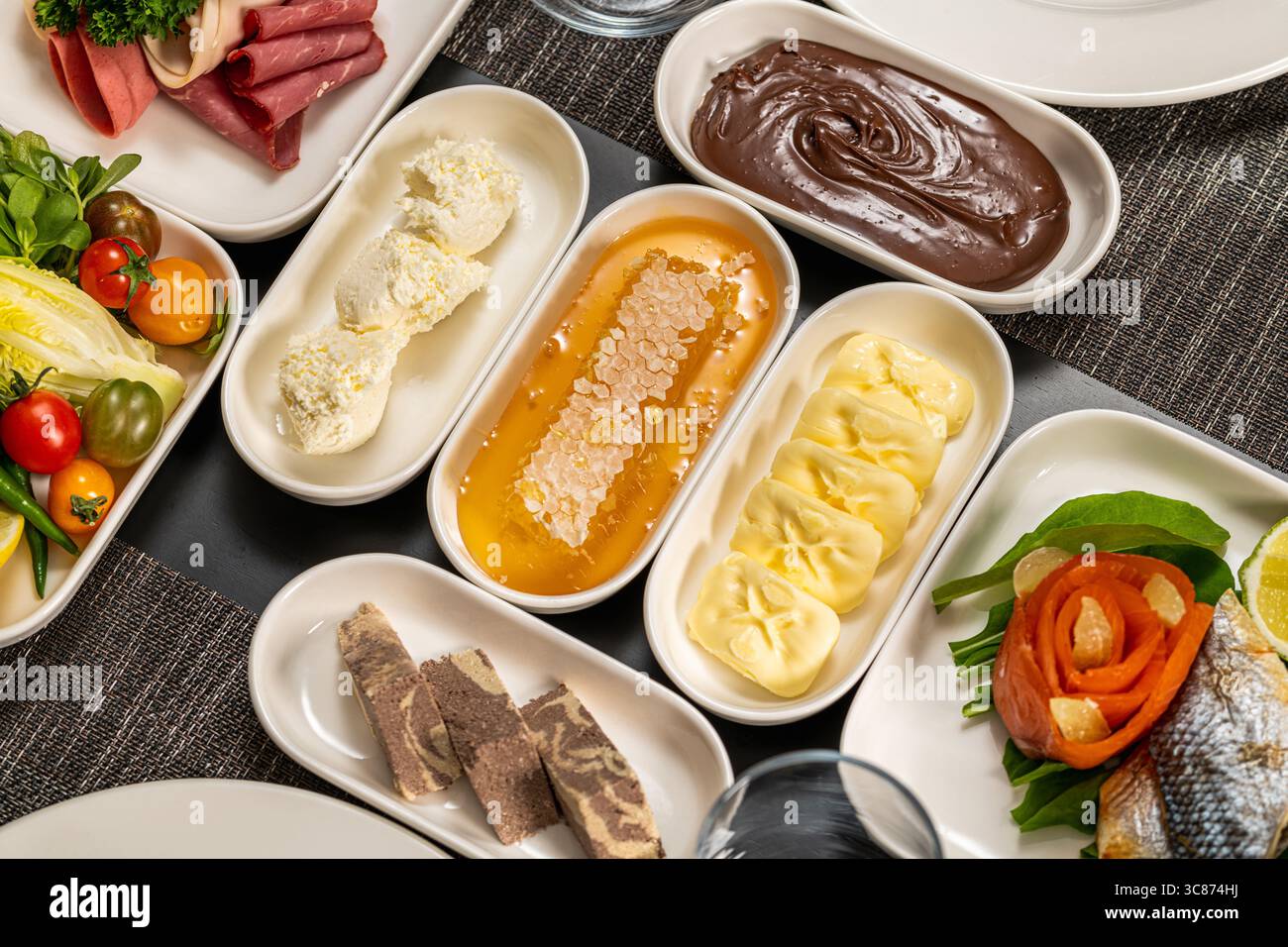 Verschiedene kalte Frühstücksplatten mit Aufstrichen, Gemüse und Wurstwaren Stockfoto