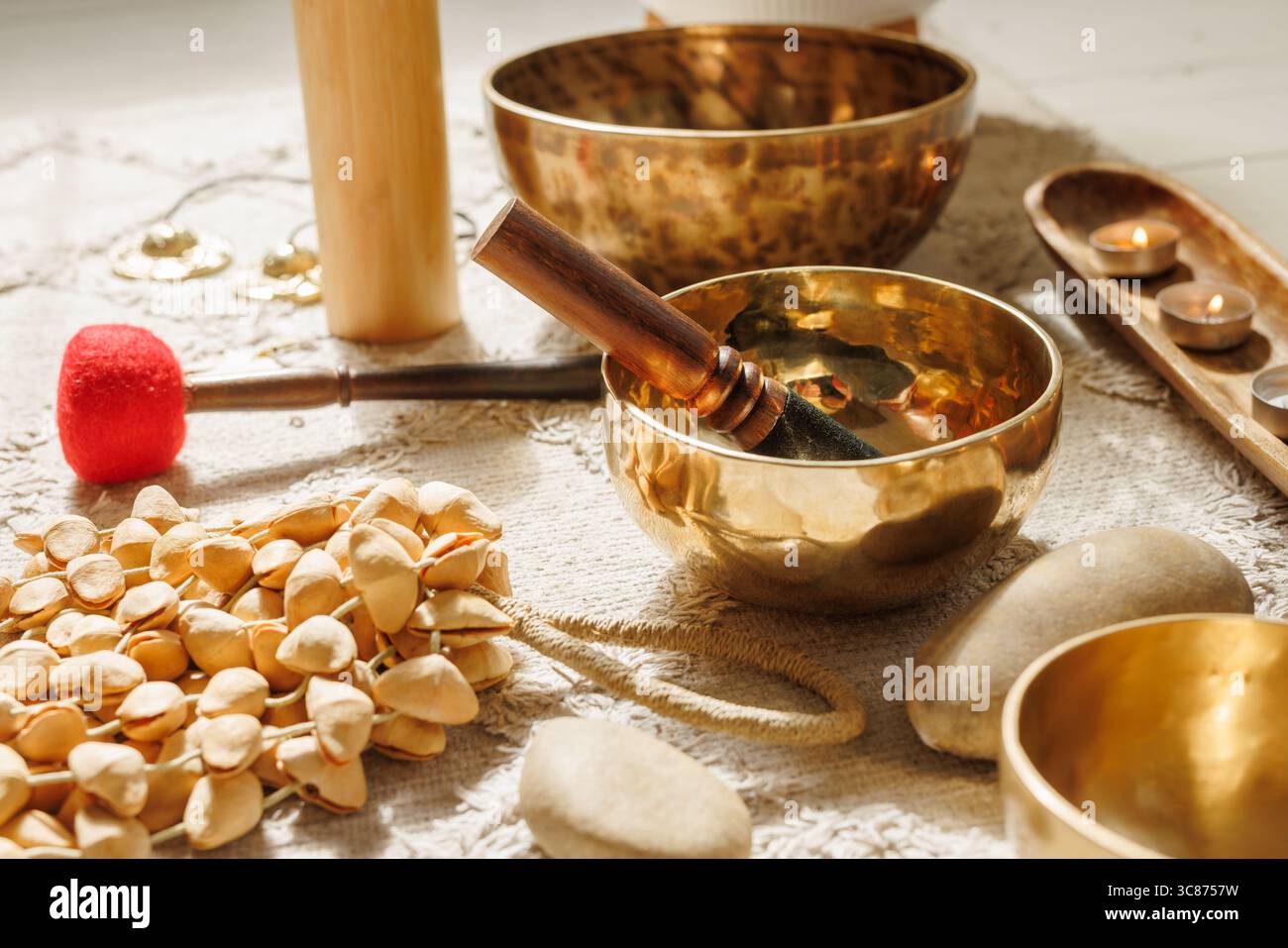 Nahaufnahme von Klangschalen, Schlägern, Natursteinen und rituellen Accessoires für Wellness, Meditation und ganzheitliche Heilung Stockfoto