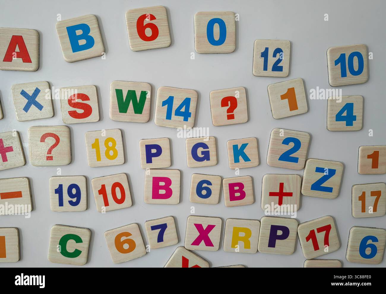 Magnetbuchstaben und Zahlen auf dem Kühlschrank. Symbole Chaos. Stockfoto