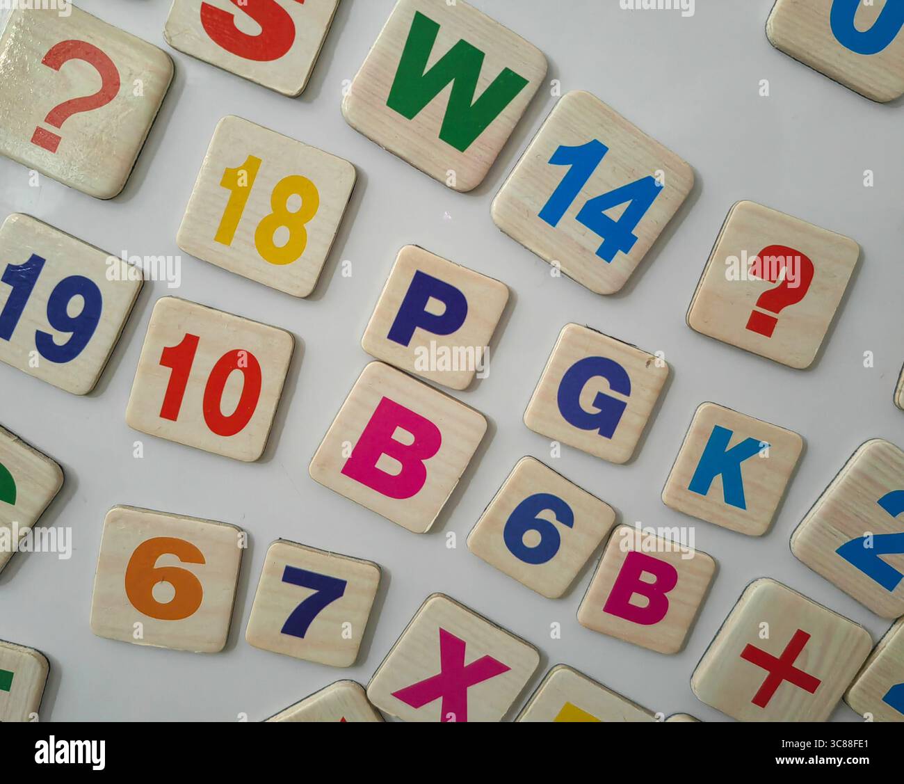Magnetbuchstaben und Zahlen auf dem Kühlschrank. Symbole Chaos. Stockfoto