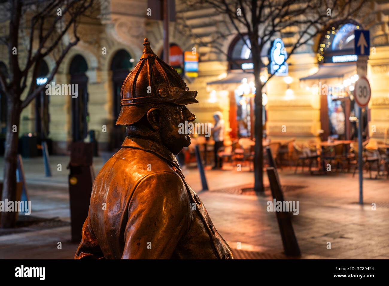 Bronzestatue des Polizisten wacht nachts über die Straßen der Stadt im historischen Stadtzentrum von Budapest Stockfoto
