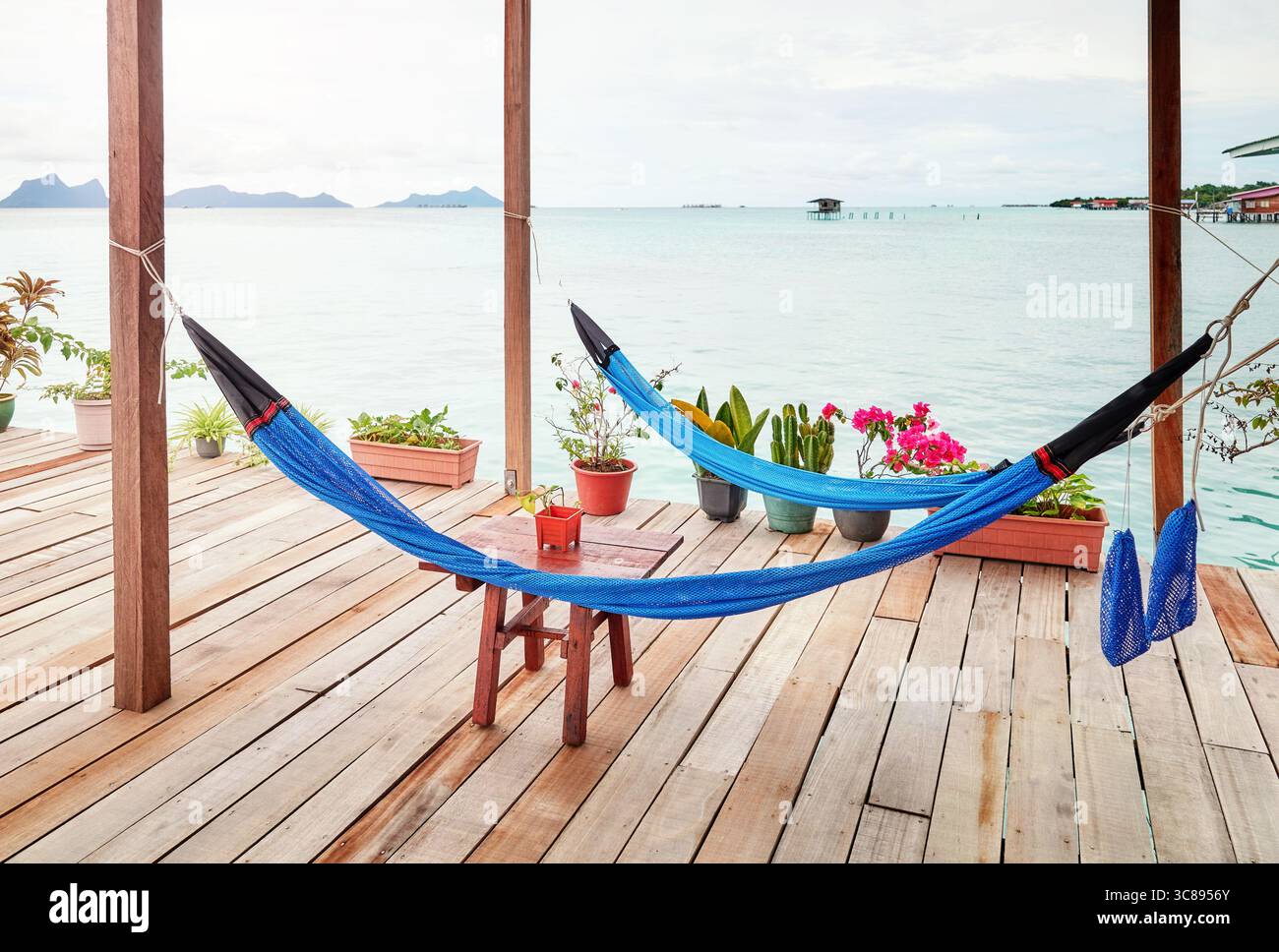 Hängematten auf einer Holzplattform über dem Wasser, Urlaubsentspannungskonzept. Stockfoto Hängematten auf einer Holzplattform über dem Wasser, Urlaubsentspannungskonzept. Stockfoto