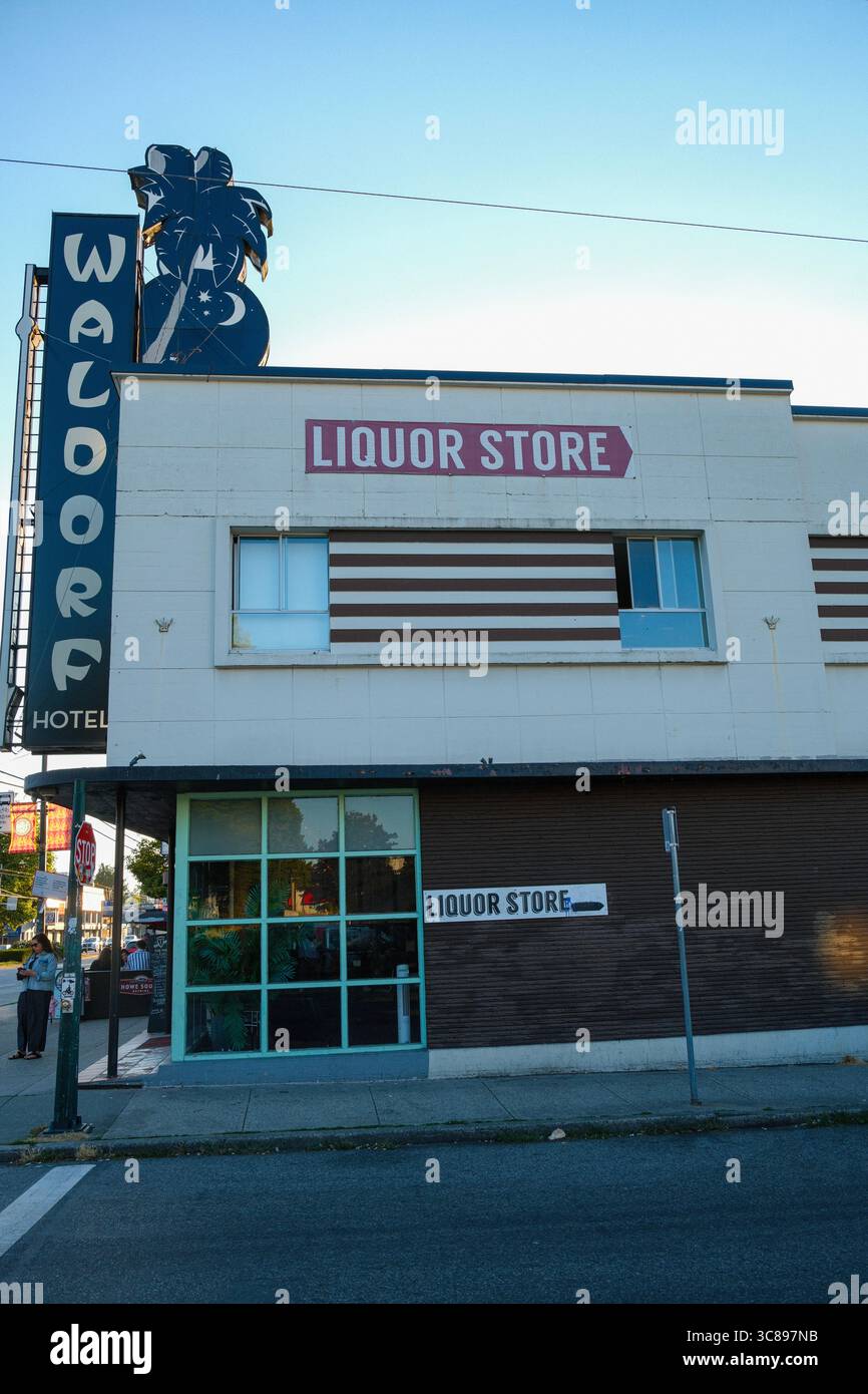 Das historische Hotel im Waldorf mit seinem Neonschild entlang der East Hastings Street & einem Liquor Store im hinteren Teil von East Vancouver, BC. Stockfoto