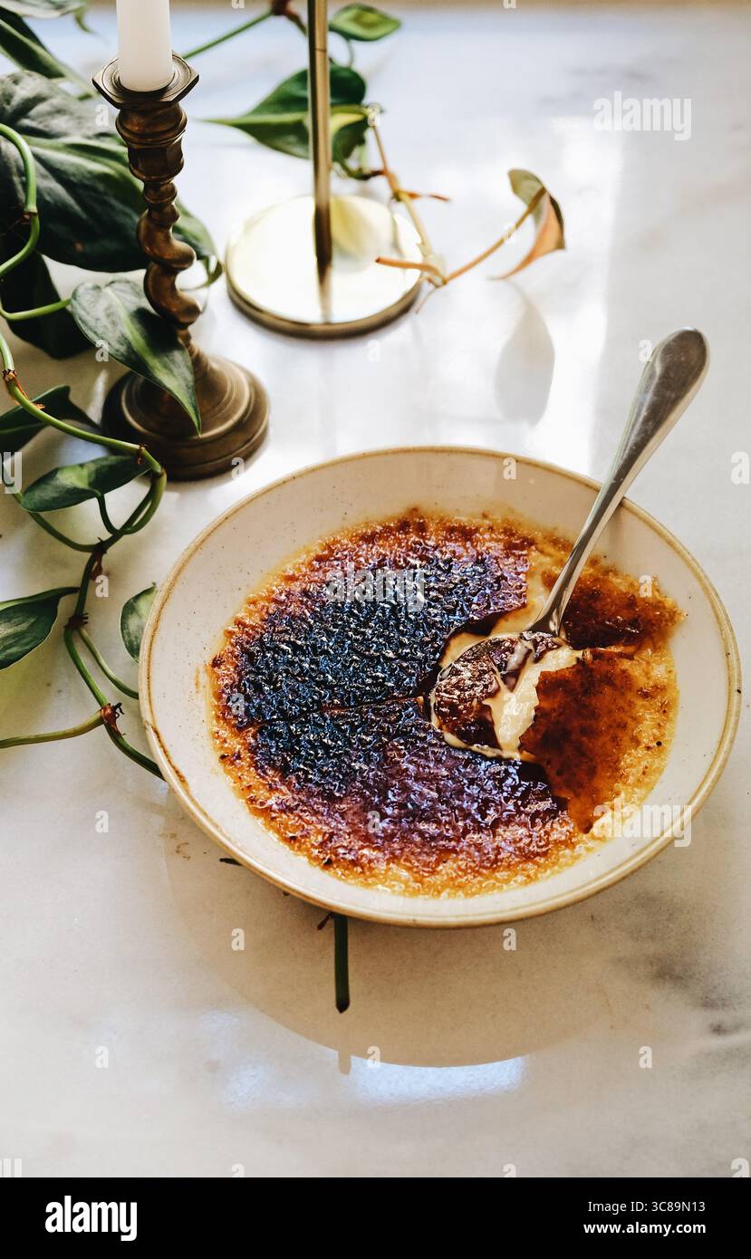 Crème brûlée ist ein klassisches französisches Dessert mit einer reichhaltigen, cremigen Vanillepudding-Basis und einer kontrastierenden Schicht harten, karamelisierten Zuckers. Stockfoto