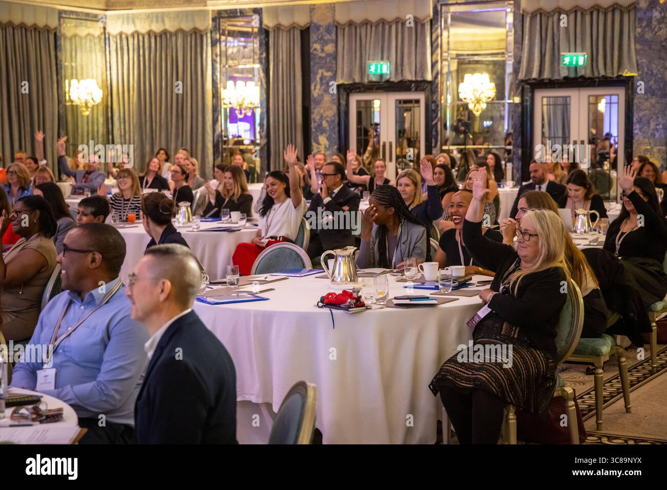 Konferenzteilnehmer sitzen an Tischen Stockfoto