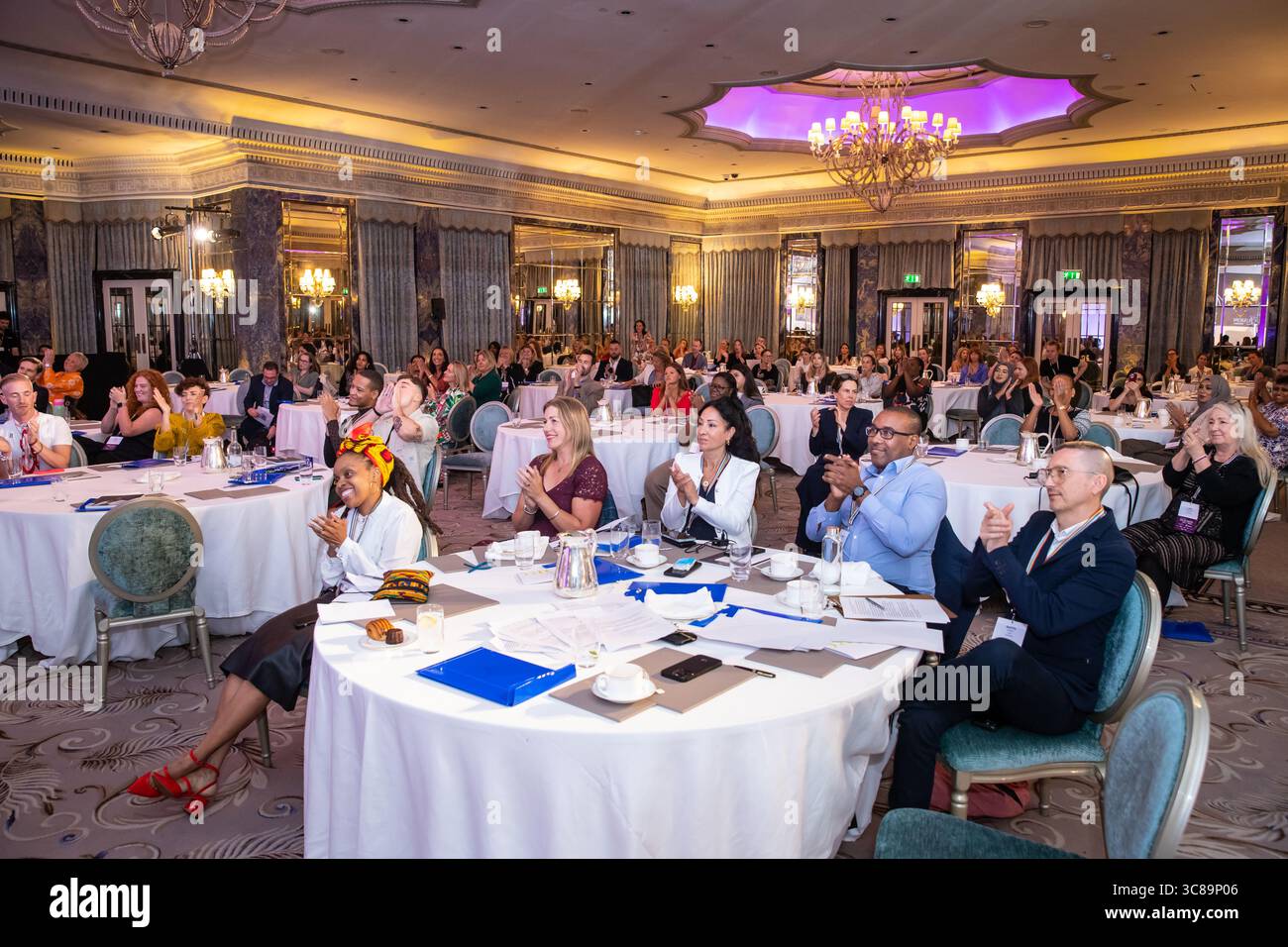 Konferenzteilnehmer sitzen an Tischen Stockfoto
