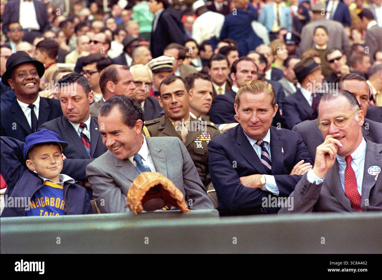 US-Präsident Richard M. Nixon genießt Baseball am Eröffnungstag mit Bob Short (rechts von Nixon) und Baseballkommissar Bowie Kuhn (ganz rechts mit Brille), Robert F. Kennedy Stadium, Washington, D.C., USA, White House Photo Office, 7. April 1969 Stockfoto