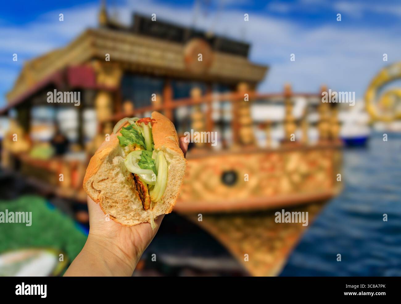 Ein Koch verwendet eine Zange, um frischen Fisch auf einer heißen Grillplatte zu grillen und ihn für ein beliebtes Fisch-Sandwich zu grillen, bei Ofne des Balik Sandwichbootes in Istanbul, Türkei Stockfoto