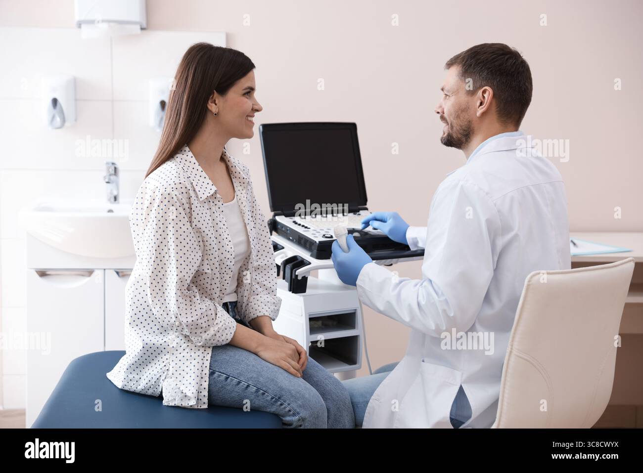 Sonographin berät Frau vor ihrer Ultraschalluntersuchung in der Klinik Stockfoto