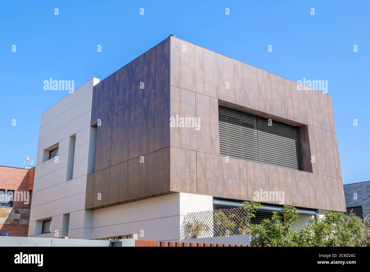 Markantes Modernes Haus Mit Holzähnlicher Verkleidung Und Minimalistischem Design Unter Blauem Himmel. Zeitgenössische Architektur, luxuriöses Haus, Außenansicht, Gebäude Stockfoto