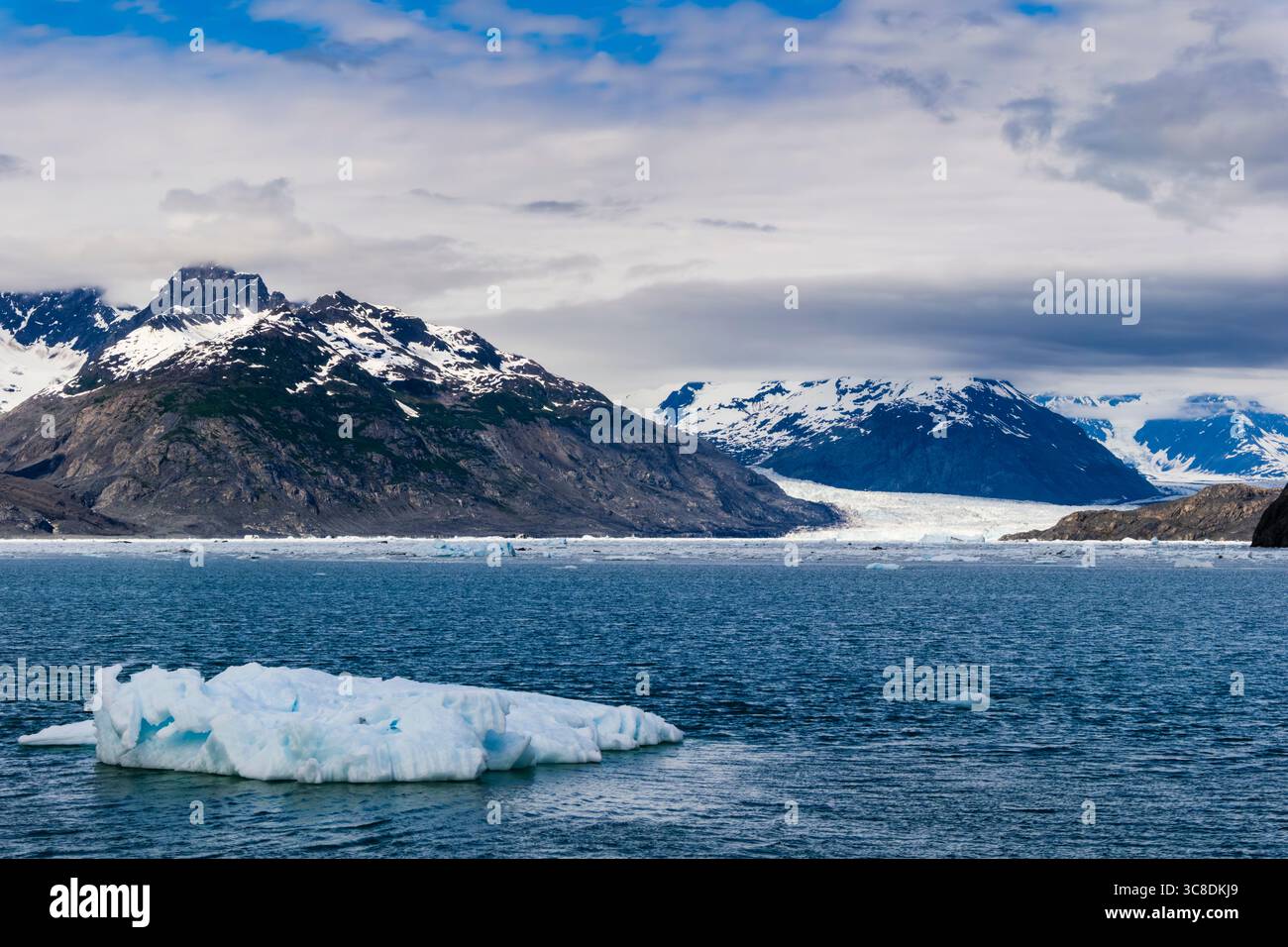 Kleiner Eisberg, der in der Columbia Bay mit dem Columbia Gletscher und den Bergen dahinter schwimmt. Prince William Sound, Valdez, Alaska, USA Stockfoto