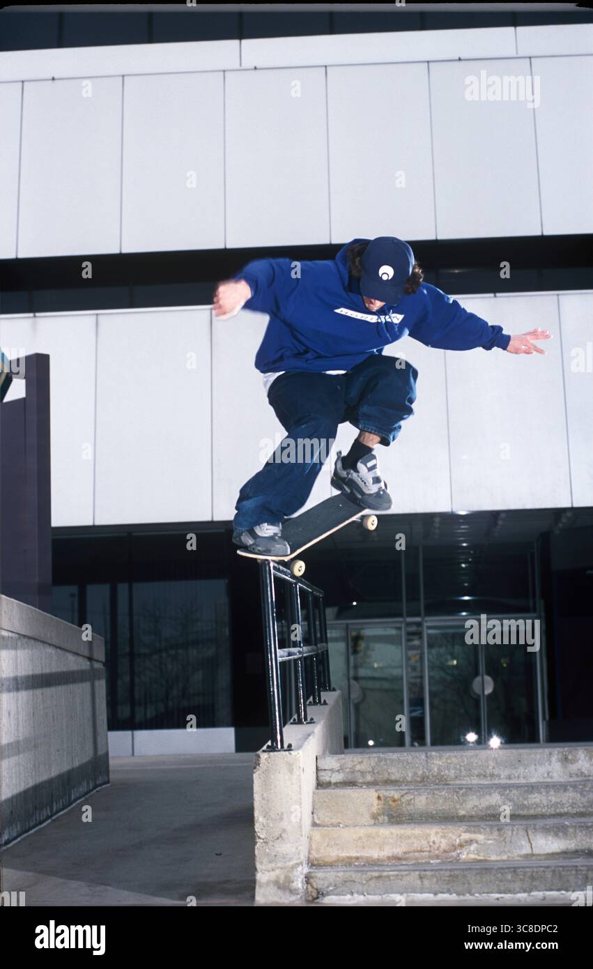 Ein Skateboarder, der einen Trick am Handlauf macht. Stockfoto