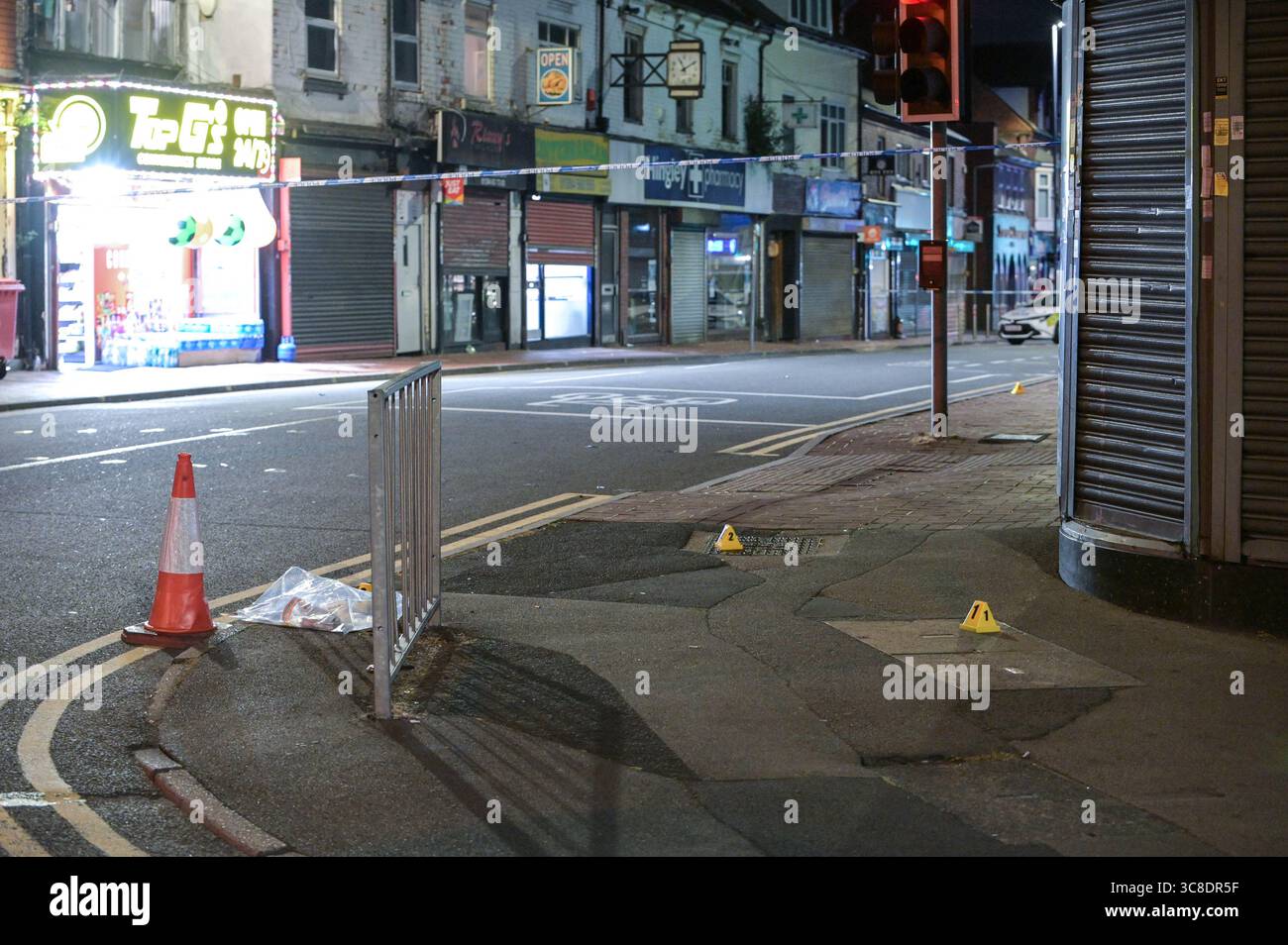 High Street, Cradley Heath, 4. August 2025: Polizei und Forensiker von West Midlands am Tatort eines Doppelerstochs in der Cradley Heath High Street am Sonntag, den 3. Abend. Zwei Männer im Alter von 22 und 42 Jahren erstochen sich gegenseitig in der Region Sandwell in den West Midlands. Die Polizisten haben die verletzten Männer wegen des Verdachts auf versuchten Mord verhaftet. Ein Laden, in dem der Angriff stattfand, war voller erster Hilfe und Kleidung. Kleine Blutflächen waren auch auf dem Boden zu sehen. WMP-Erklärung: "Zwei Männer wurden nach einer Störung in Cradley Heath verhaftet. „Wir wurden gestern Abend (3. August) gegen 20:20 Uhr angerufen Stockfoto