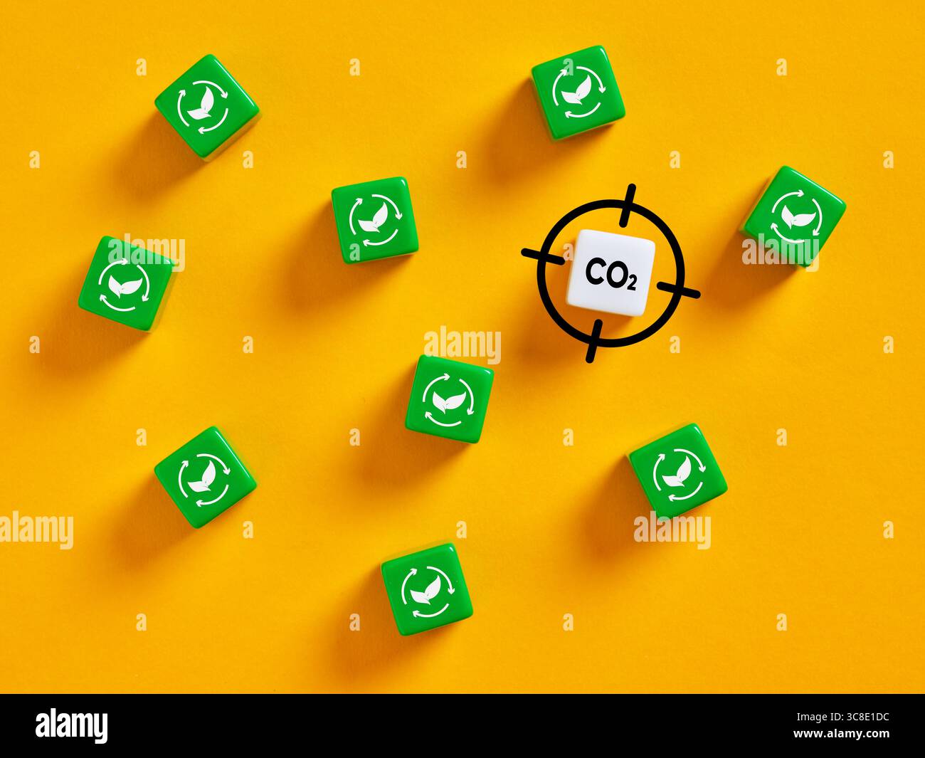 Grüne Recyclingsymbole umgeben einen gezielten CO2-Emissionsblock und verdeutlichen die Bedeutung der Kreislaufwirtschaft für die Verringerung des CO2-Fußabdrucks. Targeting Stockfoto