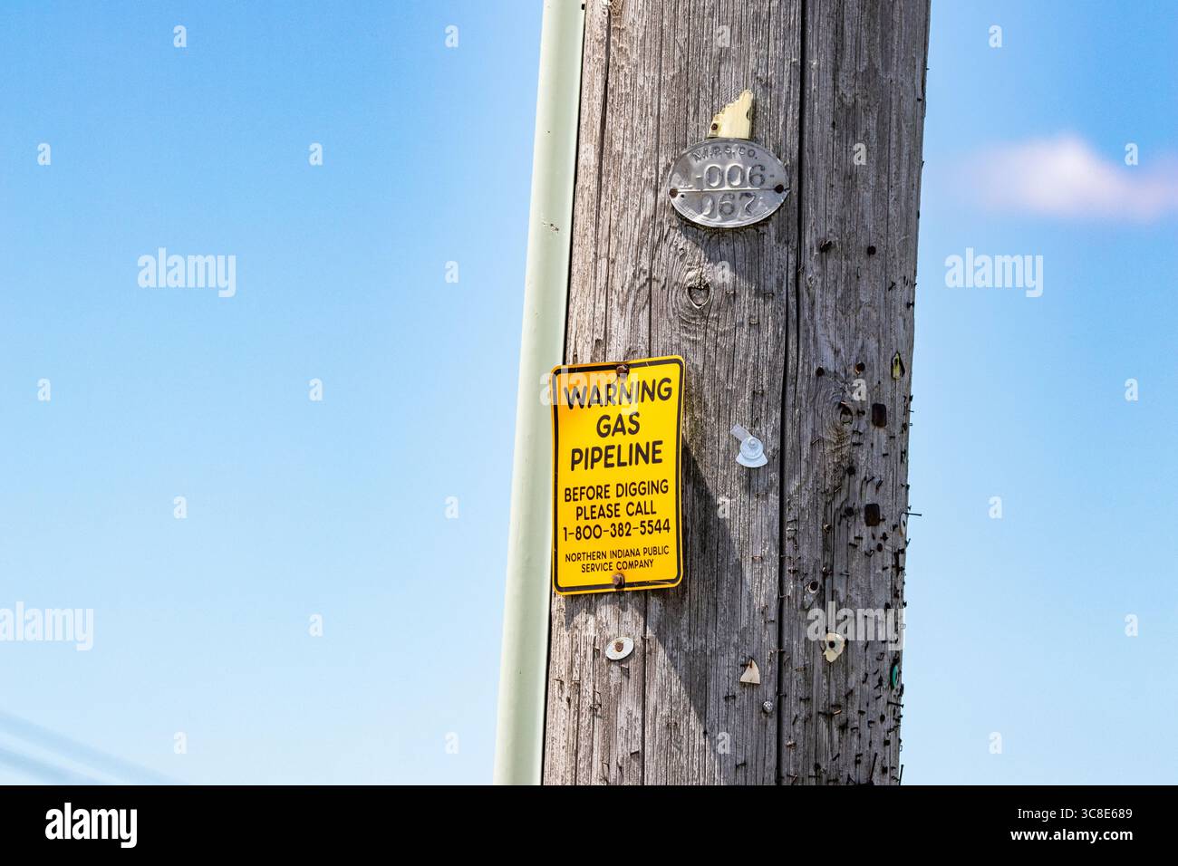 Gelbes NIPSCO-Warnschild an einem Stab Stockfoto