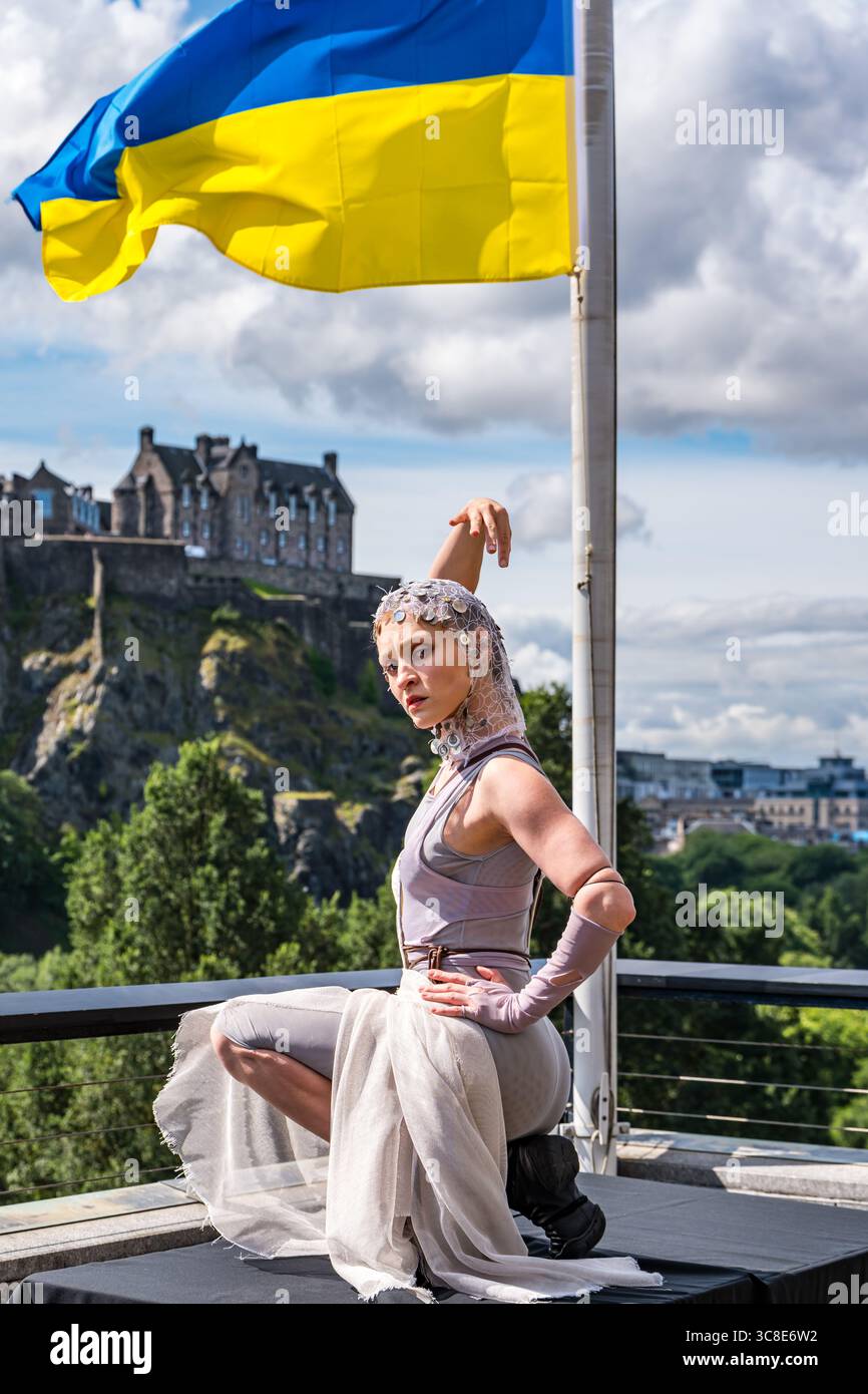Ukrainische Darstellerin Nina Khyzhna mit Blick auf Edinburgh Castle und ukrainische Flagge, Edinburgh Festival Fringe, Scoltand, Großbritannien Stockfoto