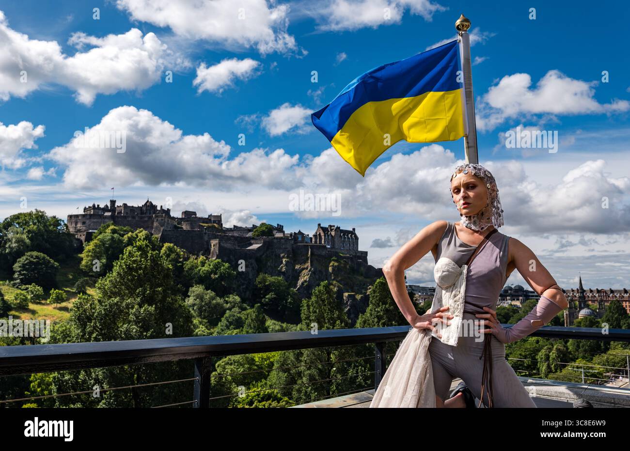 Ukrainische Darstellerin Nina Khyzhna mit Blick auf Edinburgh Castle und ukrainische Flagge, Edinburgh Festival Fringe, Scoltand, Großbritannien Stockfoto