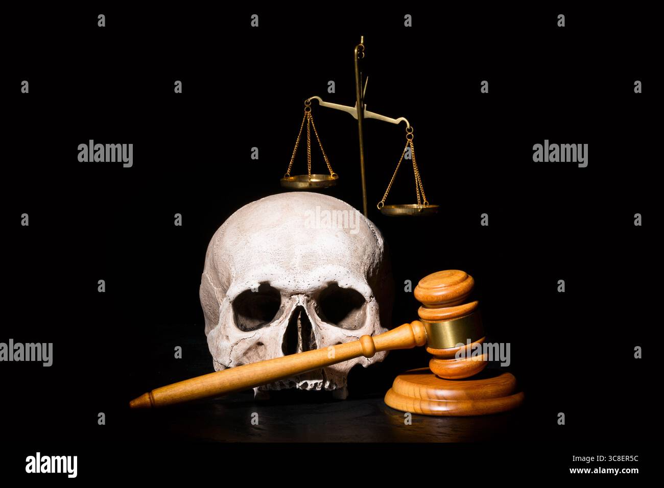 Rechtsrecht, Gerechtigkeit und Mordkonzept. Hölzerner Hammer in der Nähe des menschlichen Schädels und Balance Messingskalen vor schwarzem Hintergrund Stockfoto