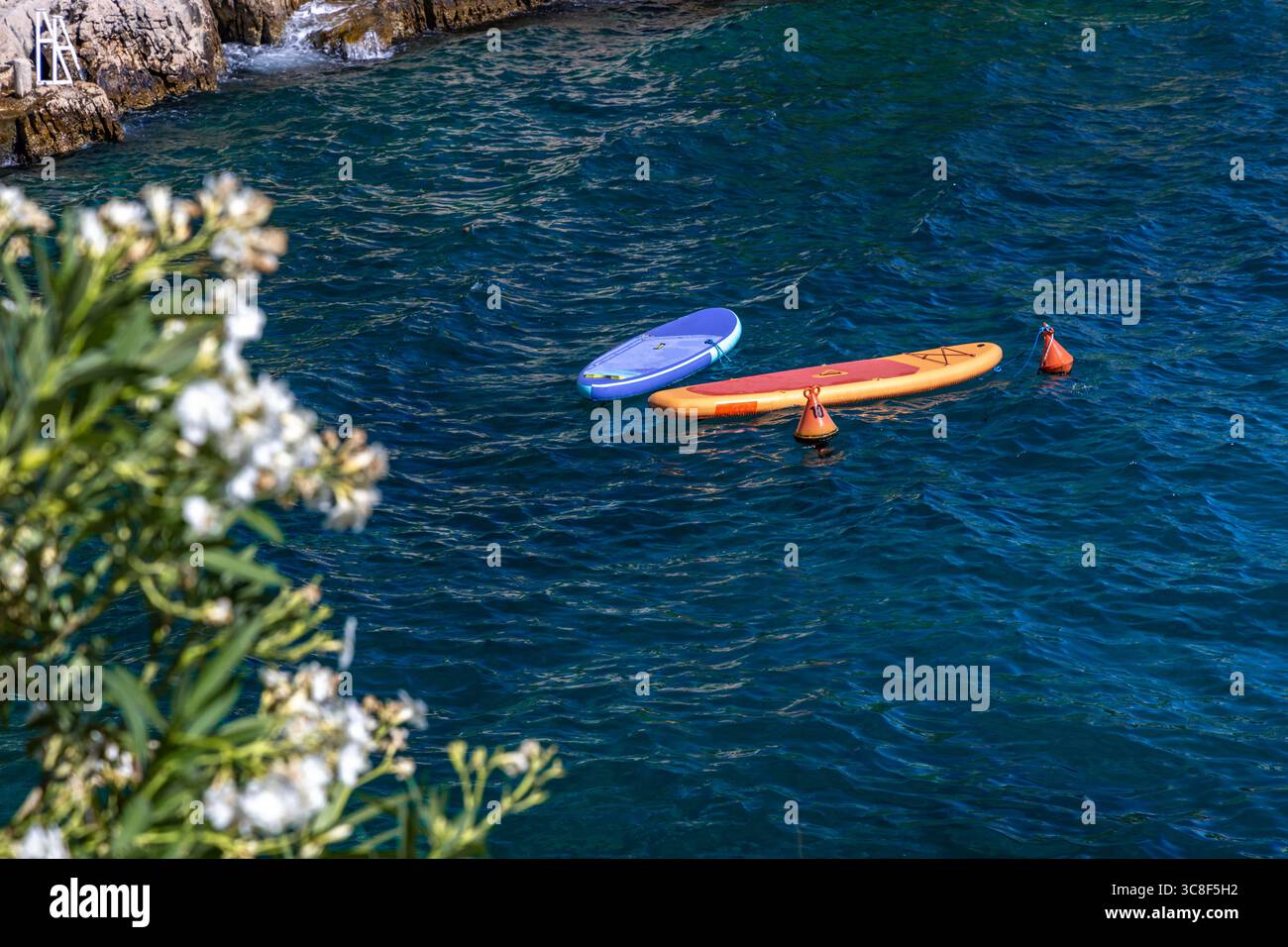 Bunte Surfbretter in der Adria vor der Küste von Ciovo, Kroatien, verlassene SUPs ohne Menschen, Wasserrettung Stockfoto