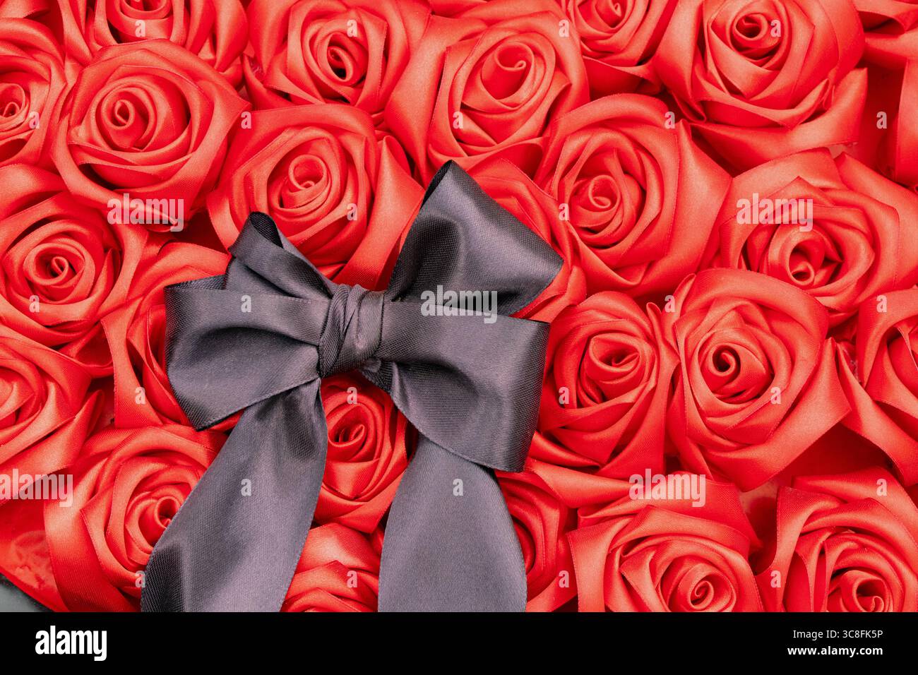 Ein Trauerstrauß aus roten Rosen mit schwarzem Bogen liegt als Opfergabe auf der Gasse der Erinnerung, ein Symbol der Trauer, der Erinnerung und des Respekts für die gefallenen Helden Stockfoto