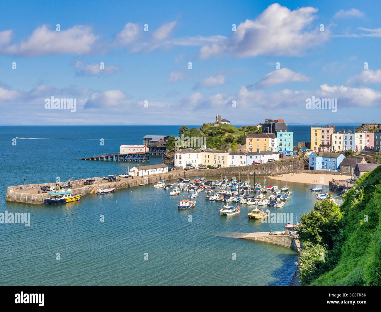 Tenby, Pembrokeshire, Wales, Vereinigtes Königreich, mit dem Hafen, Harbour Beach, farbenfrohe Häuser und Castle Hill. Stockfoto