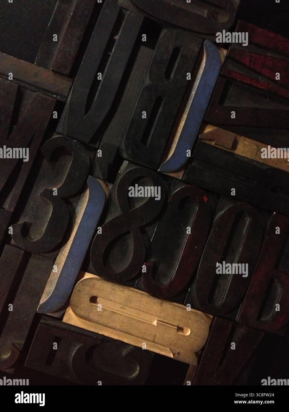 Nahaufnahme verschiedener Vintage-Holzdruckblöcke mit Letterpress-Zeichen, die ein abstraktes Muster bilden und an traditionelle Drucktechniken erinnern Stockfoto