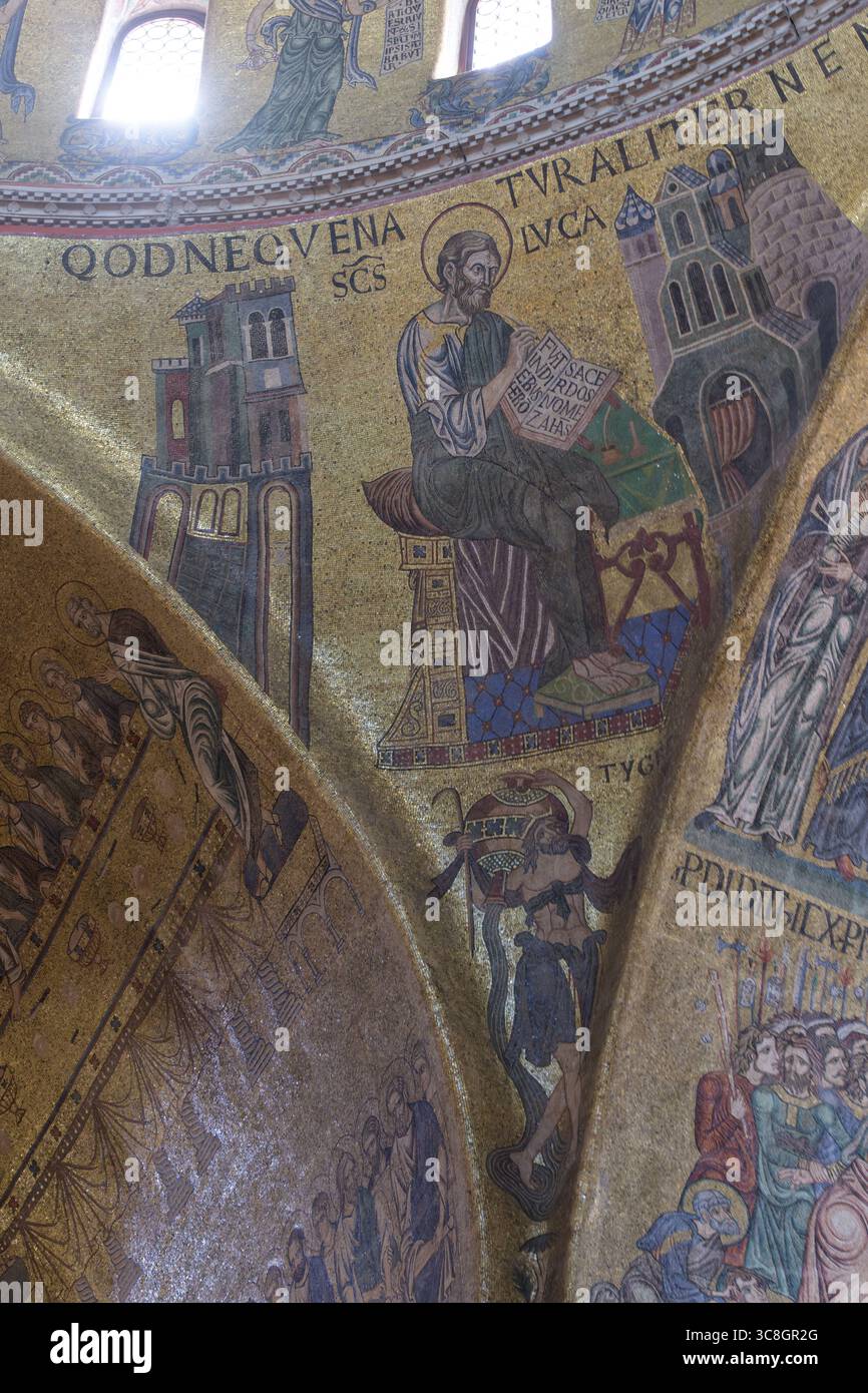 Goldenes Mosaik mit dem Heiligen Lukas, dem Evangelisten, der im Inneren des Markusdoms (Basilika di San Marco) sein Evangelium schreibt, Stockfoto