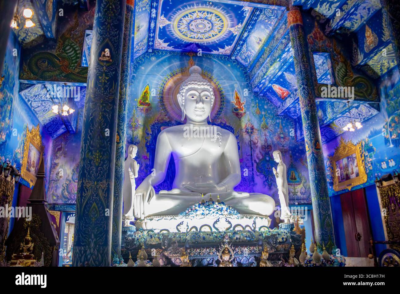 Weißer Buddha auf dem Altar im Blauen Tempel in Chiang Rai, Thailand, mit künstlicher Beleuchtung Stockfoto