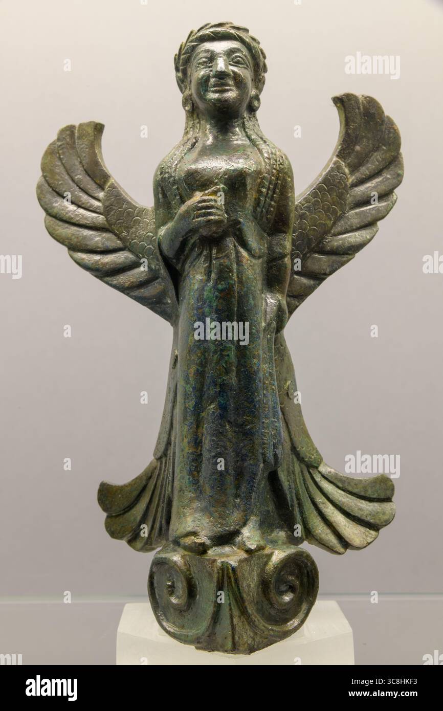 Eine bronzene geflügelte Figur aus dem 6. Jahrhundert v. Chr., die eine geflügelte Gottheit darstellt, die wahrscheinlich mit der etruskischen Mythologie in Verbindung gebracht wird und Teil einer Sammlung ist Stockfoto