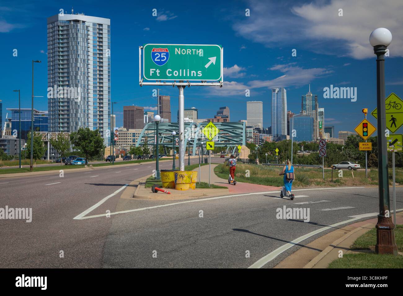 Straßenschild Wegbeschreibung nach Fort Collins, Colorado mit der Skyline von Denver im Hintergrund Stockfoto