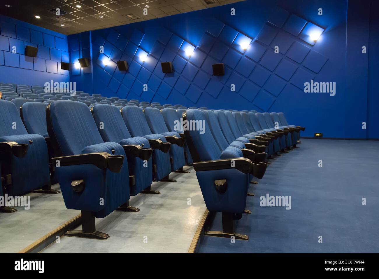 Leeres Kino-Auditorium. Leere Reihen blauer Theater- oder Filmsitze. Stockfoto
