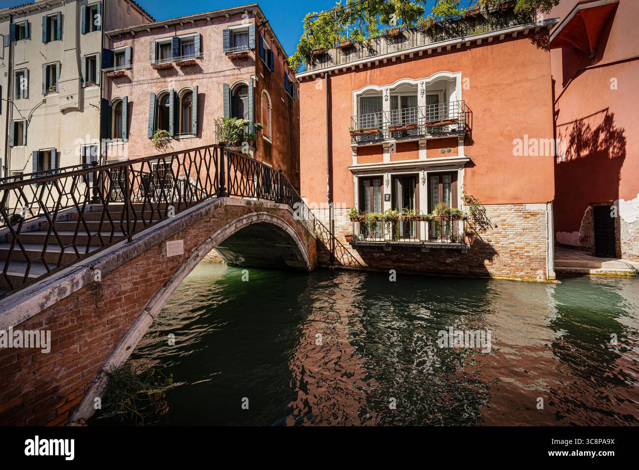 Farbenfrohe Kanalhäuser und eine bezaubernde Steinbrücke in einer ruhigen Ecke von Venedig, Italien. Stockfoto