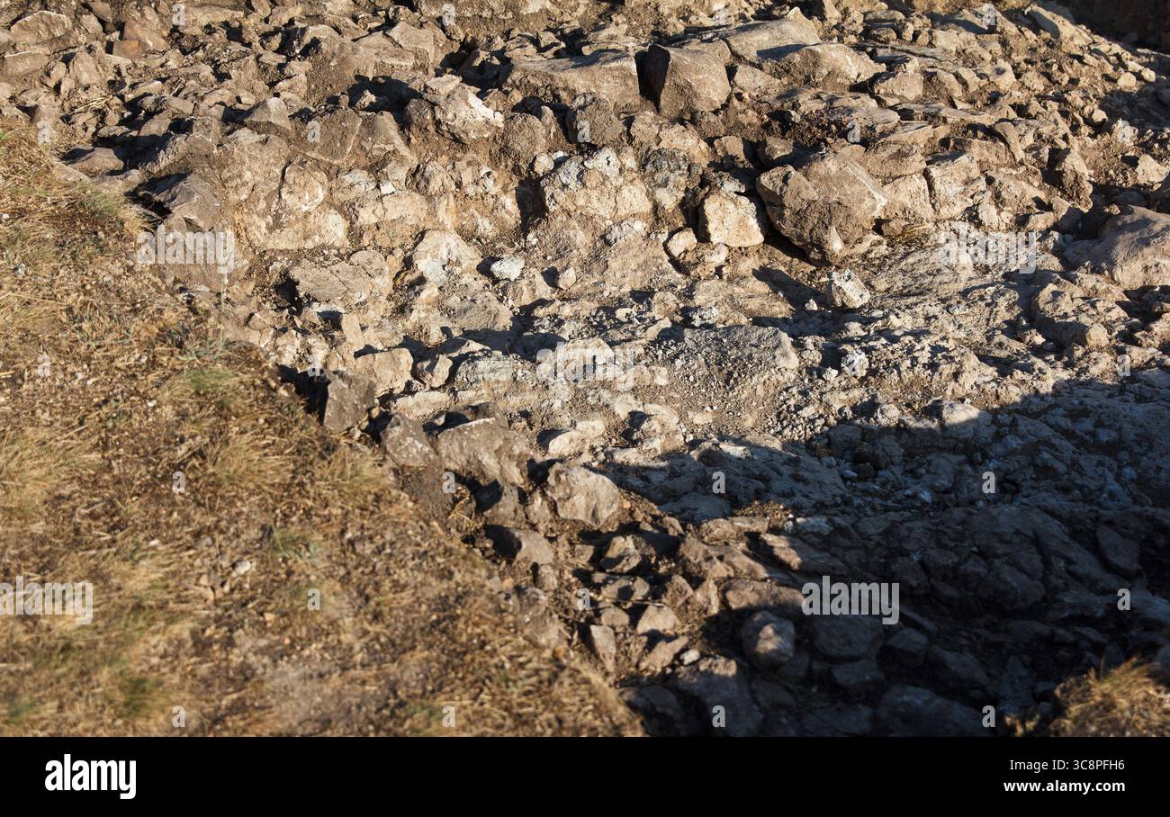 Exponierte Arbeit archäologische Grabstätte mit detaillierten Bodenschichten und kalkhaltiger Oberfläche, Tageslichtfoto, natürliches Gelände, Konzept der antiken Geschichte Exca Stockfoto