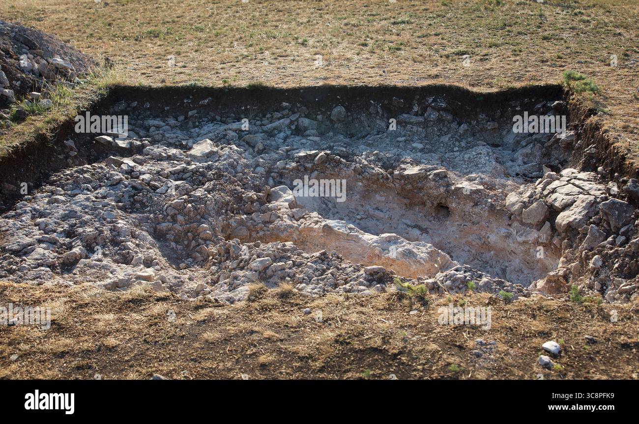 Exponierte wissenschaftliche Arbeit archäologische Grabstätte mit Bodenschichten und kalkhaltiger Oberfläche, Tageslichtfoto, natürliches Gelände, Konzept der antiken Geschichte Ex Stockfoto