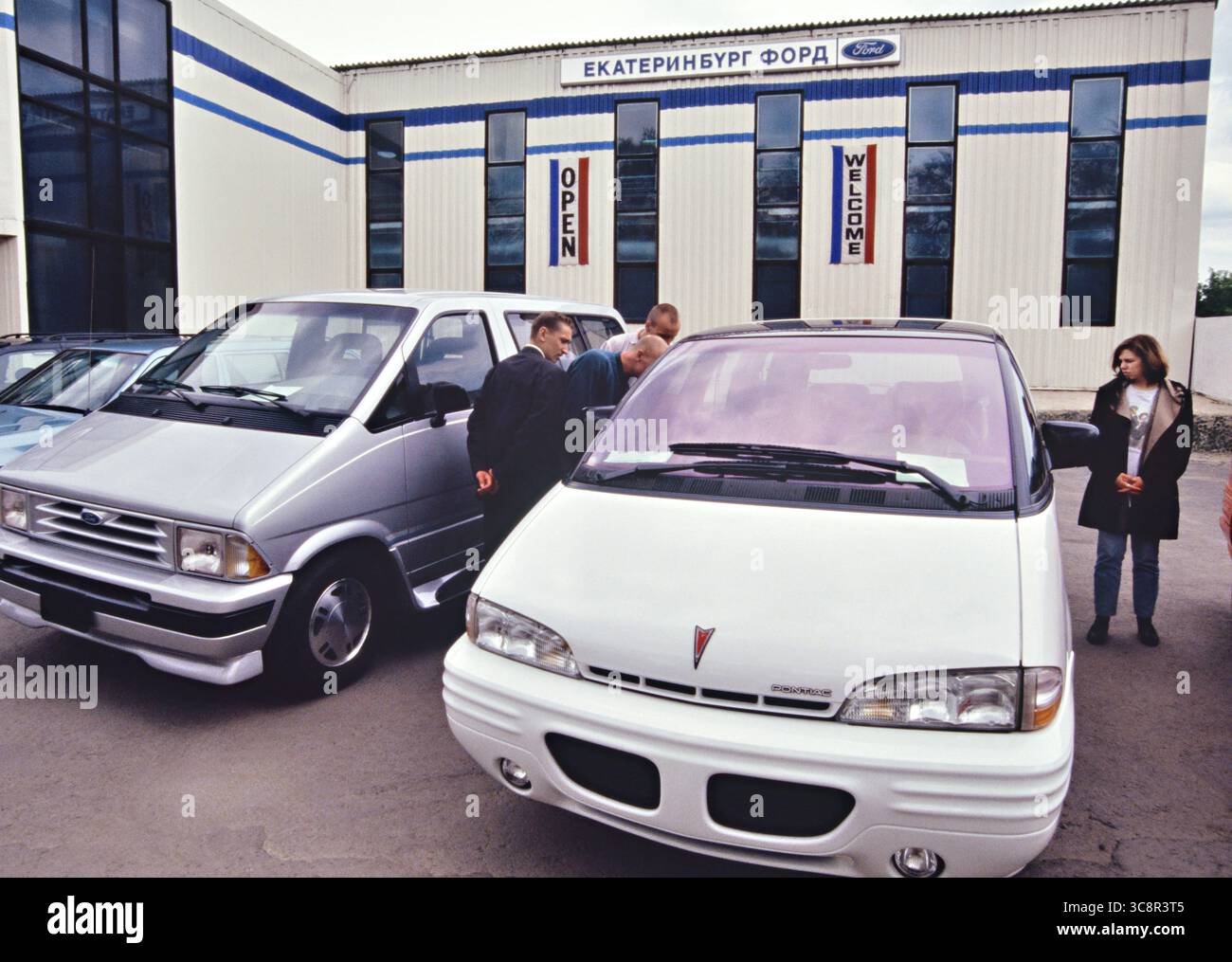 Potenzielle Käufer sehen sich Automobile der amerikanischen Ford Motor Company im ersten Ford-Händlerbetrieb im Ural am 5. Juni 1994 in Jekaterinburg, Russland, an. Ford eröffnete seine ersten post-sowjetischen Händler mit importierten Fahrzeugen, um die lokale Nachfrage nach ausländischen Autos zu befriedigen. Stockfoto