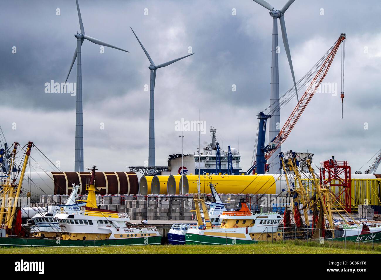 Der Seehafen von Eemshaven, Julianahaven Becken, hier lagern die Fundament-Strukturen, Monopiles, für Offshore-Windparks, die dann die eigentlichen Windräder tragen, mit großen Arbeitsschiffen werden die Bauteile zu den Windparks in der Nordsee transportiert und dort am Meeresboden verankert, darauf werden dann die Windenergieanlagen gebaut, Eemshaven, Niederlande, Windpark Logistik *** der Seehafen von Eemshaven, Julianahaven Basin, wo die Fundamentanlagen gespeichert werden. Die Komponenten werden zum W transportiert Stockfoto