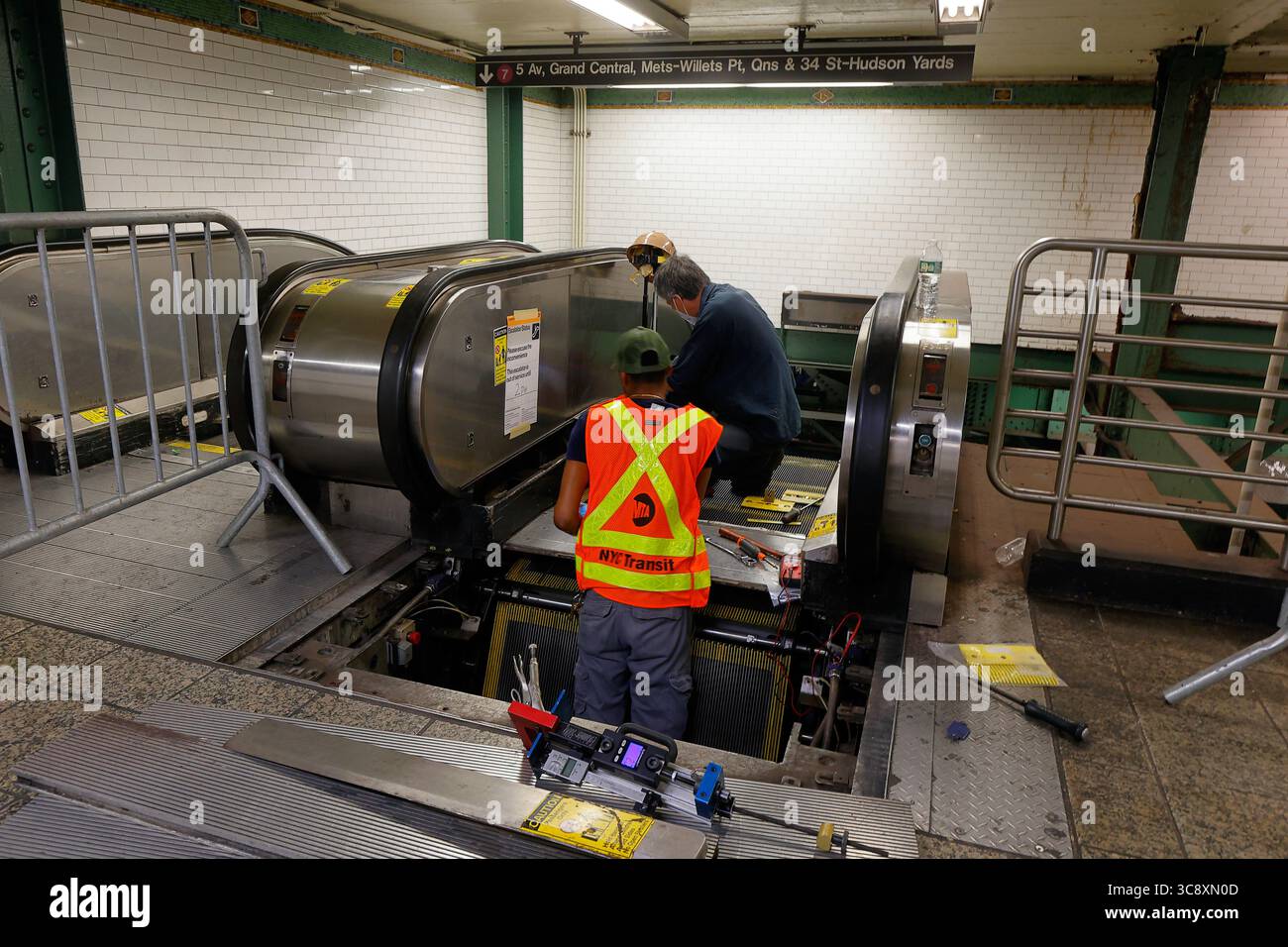 NYC Transit Elevator and Escalator Maintenance Mechaniker reparieren eine Rolltreppe an der Times Square Station in der NYC Subway, New York City. Stockfoto