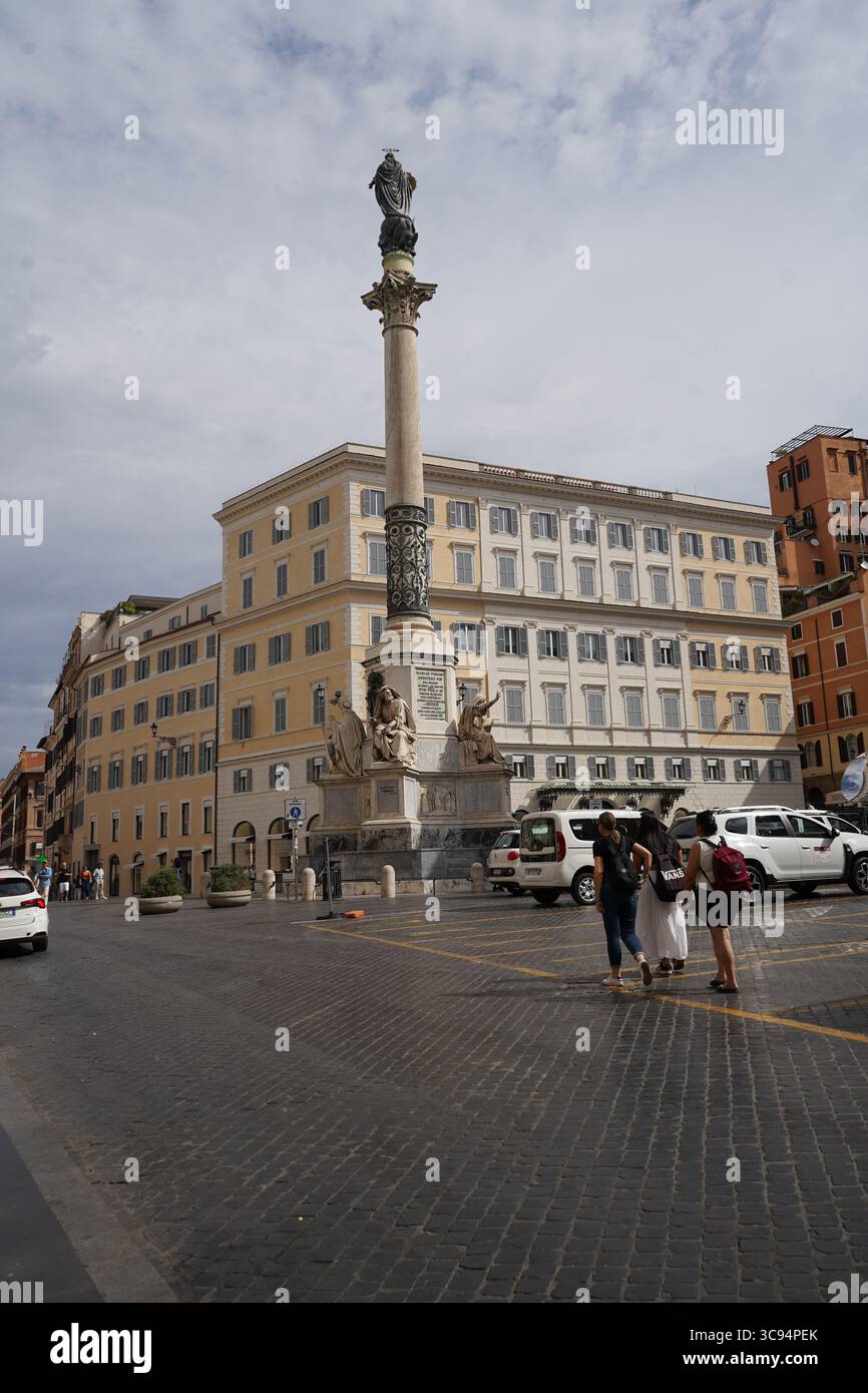 Säule der Unbefleckten Empfängnis auf der Piazza di Spagna, umgeben von historischen Gebäuden und ein paar Fußgängern. Stockfoto